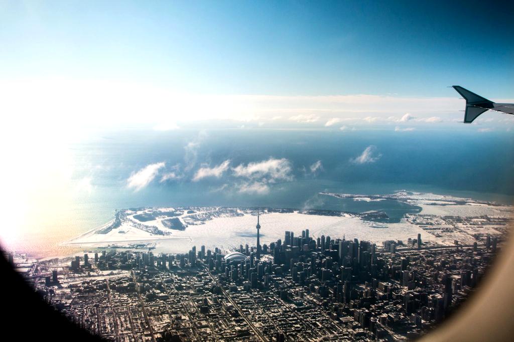 Airplane flying over a city skyline at sunset